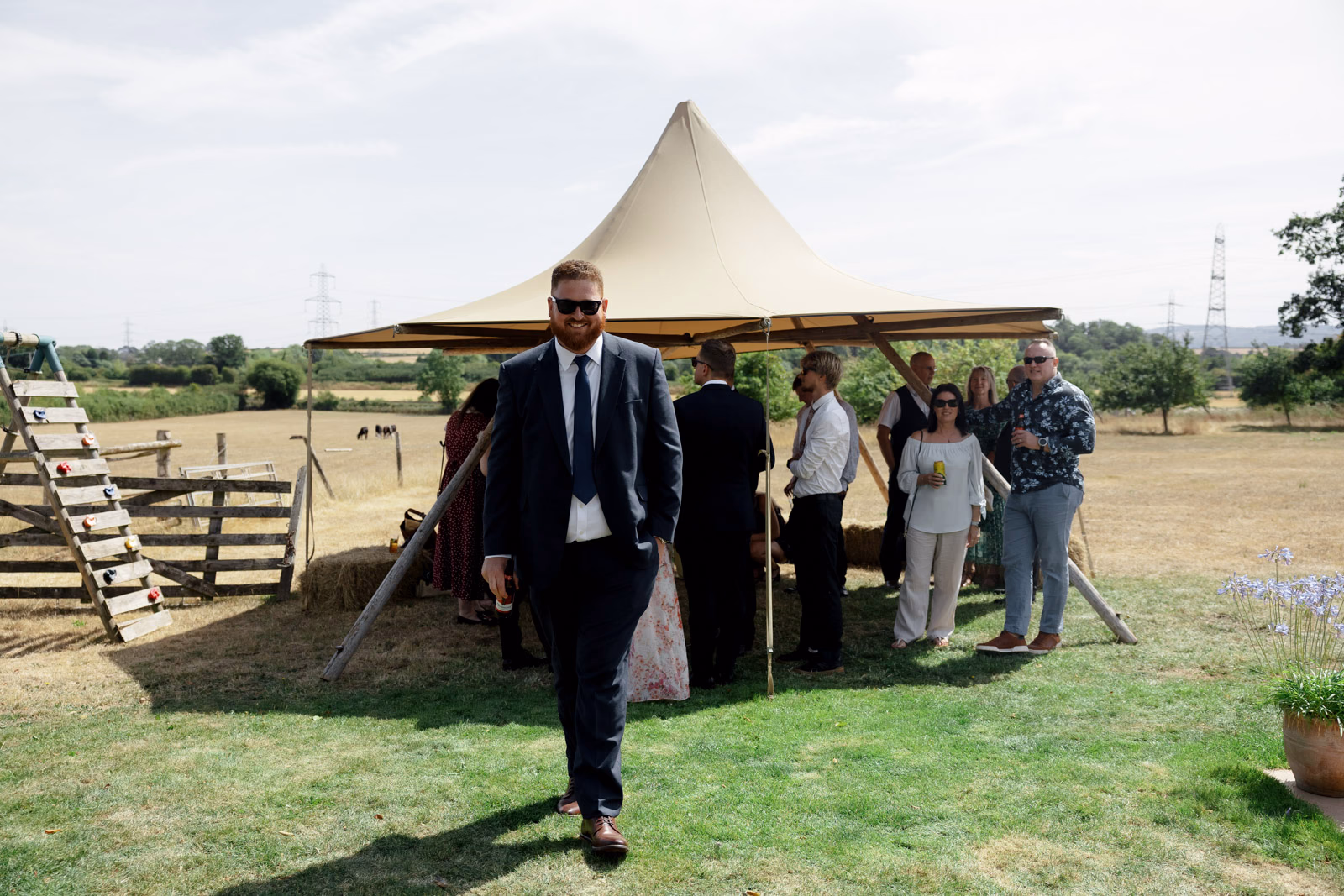 Guest walking to welcome drinks tipi at a Taunton farm wedding, photographed by Tanya Bogdan Photography