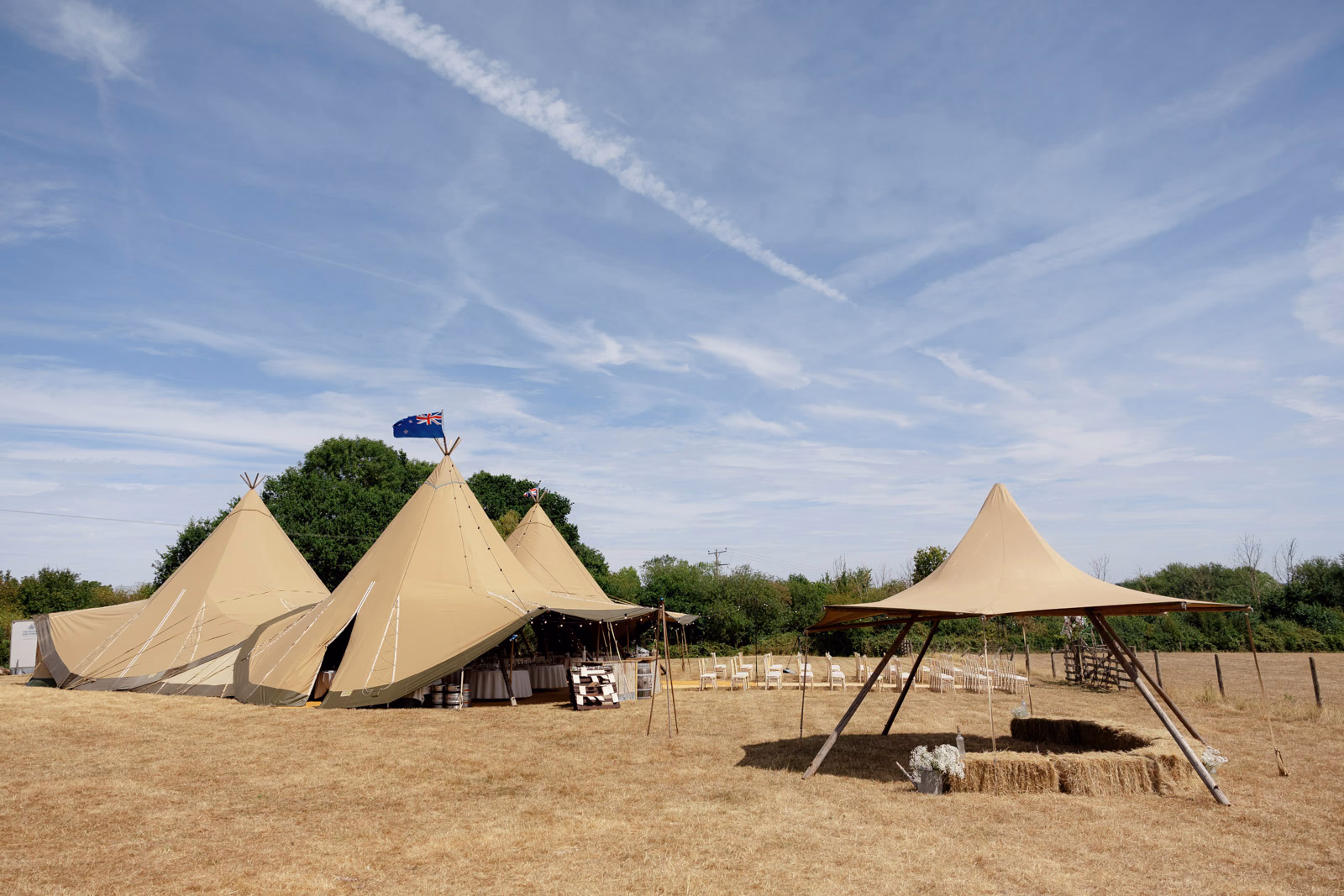 Tipi tents wedding ceremony chairs countryside at a family farm wedding in Taunton