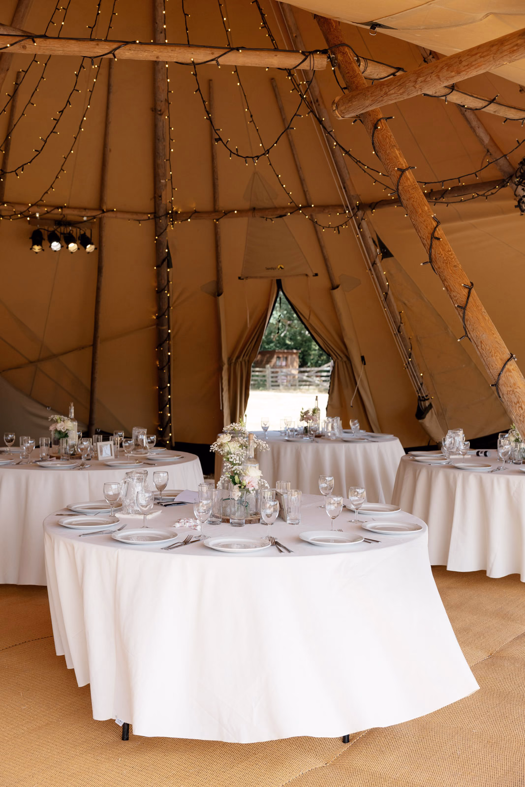 Tipi interior reception tables set at a family farm wedding in Taunton