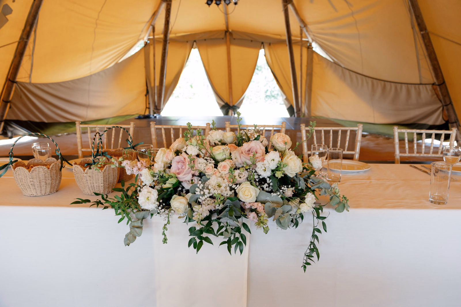 Top table floral arrangement tipi at a family farm wedding in Taunton