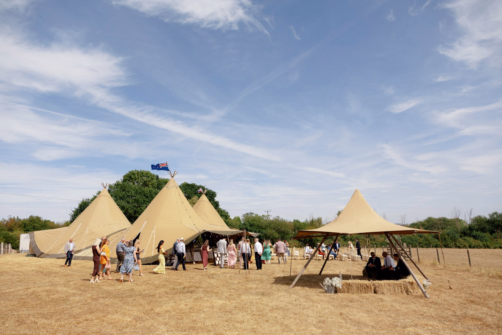 Tipi wedding guests gathering blue sky at a Taunton farm wedding, photographed by Tanya Bogdan Photography