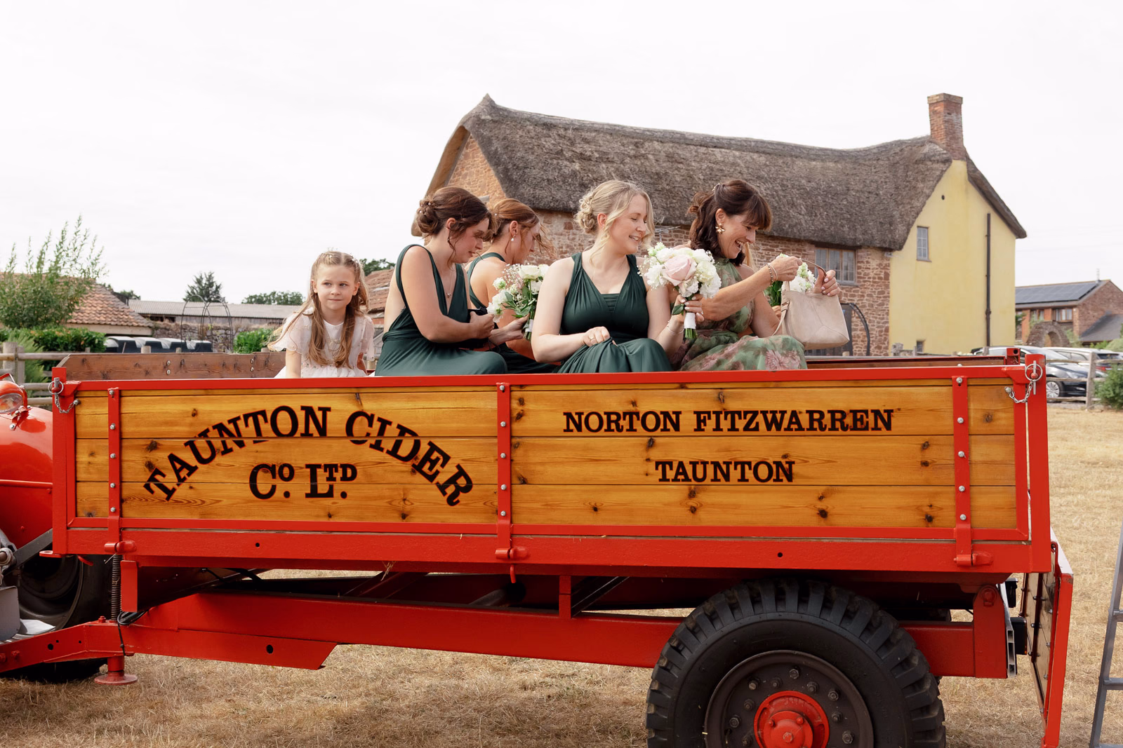Bridesmaids on trailer farmhouse background at a countryside wedding in Taunton, Somerset