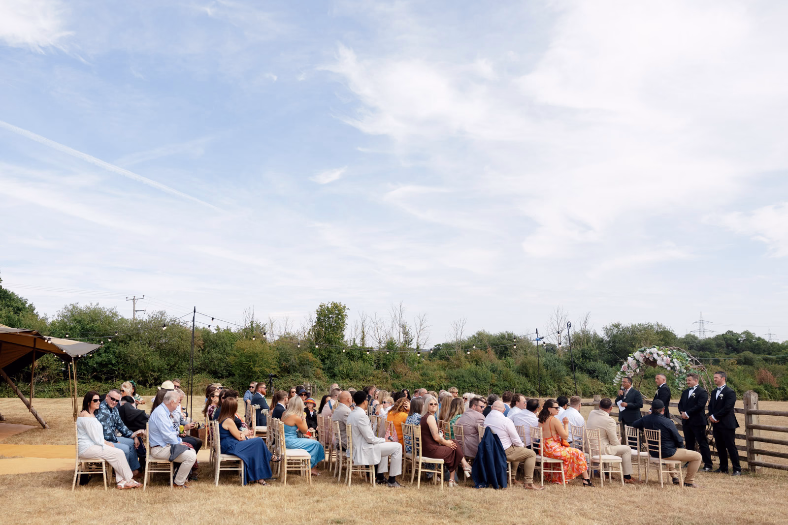 Guests seated waiting outdoor ceremony at a Taunton farm wedding, photographed by Tanya Bogdan Photography