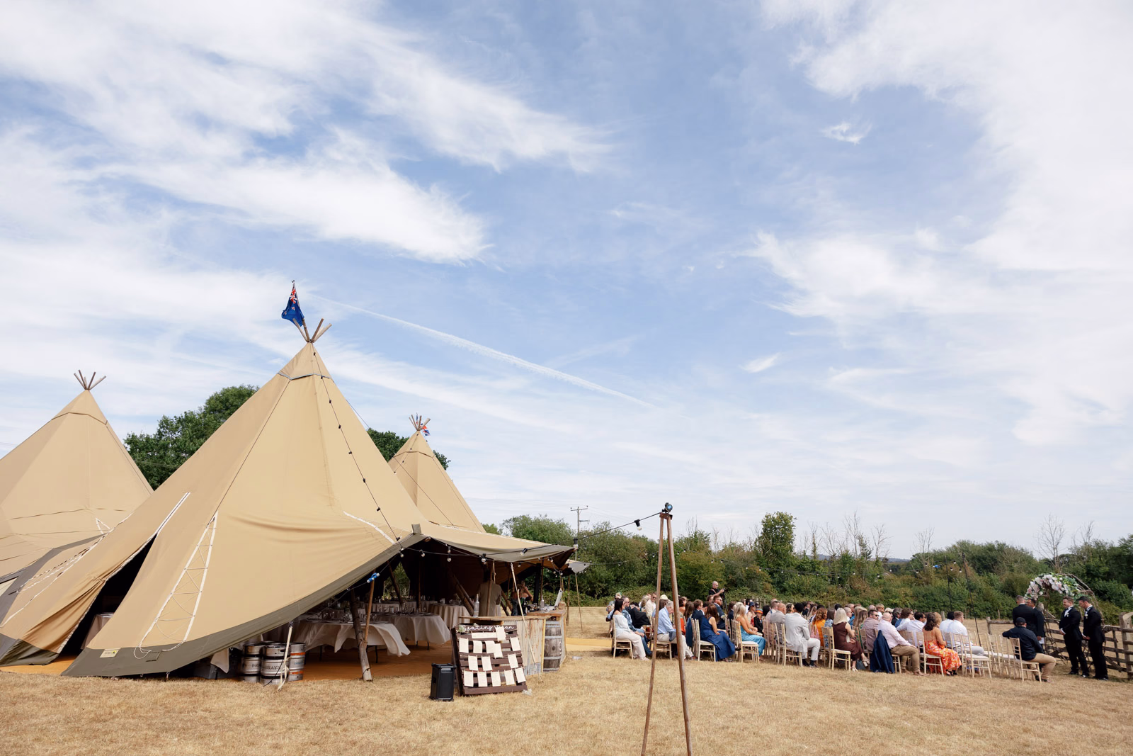 Tipi tents ceremony guests seated view at a countryside wedding in Taunton, Somerset