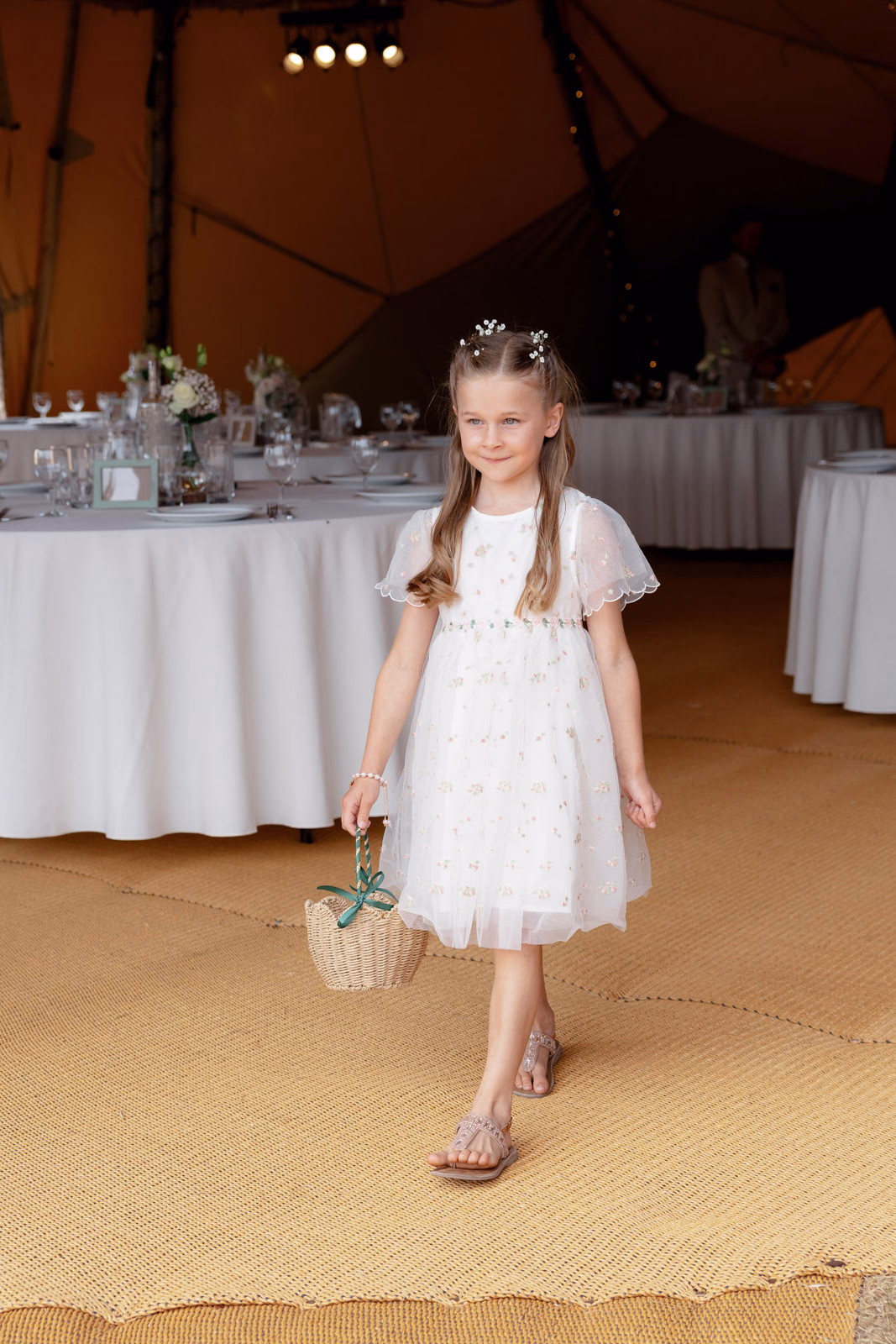 Flower girl walking with basket tipi at a Taunton farm wedding, photographed by Tanya Bogdan Photography