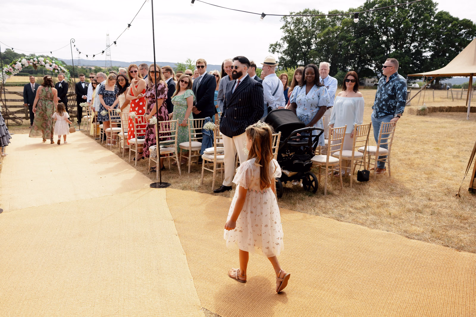 Flower girl walking down aisle at a family farm wedding in Taunton
