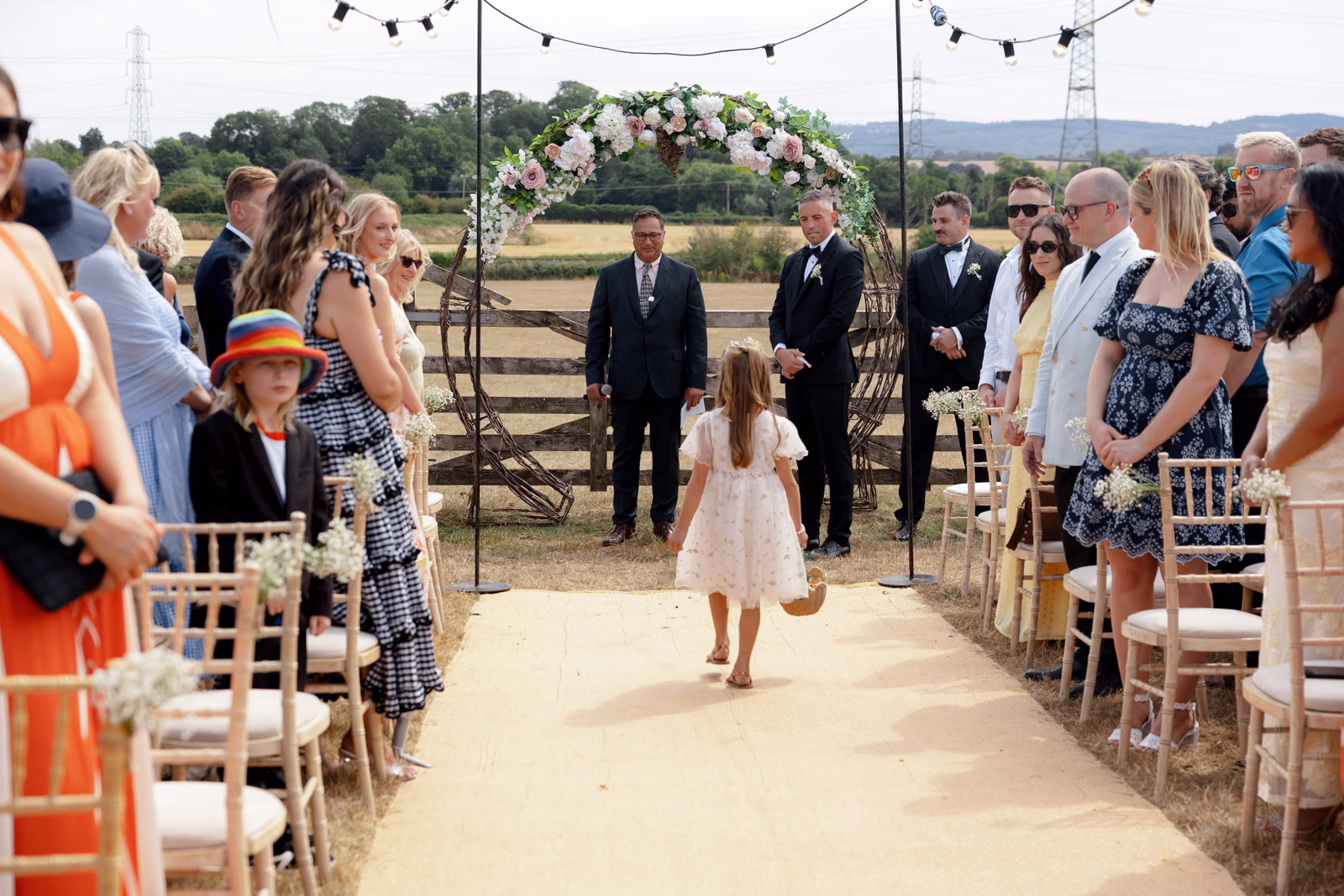 Flower girl aisle ceremony arch at a family farm wedding in Taunton