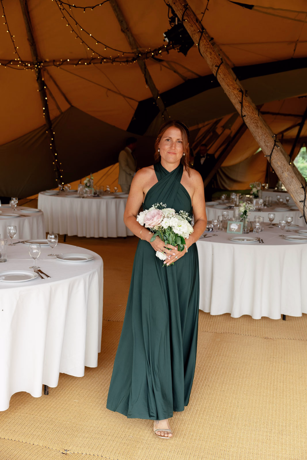 Bridesmaid with bouquet tipi entrance at a Taunton farm wedding, photographed by Tanya Bogdan Photography