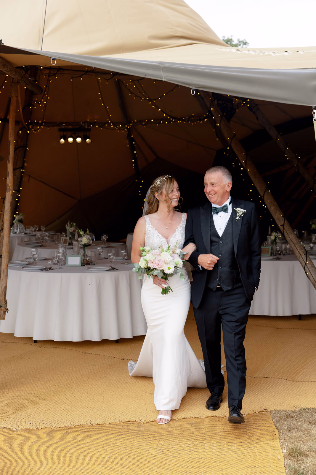 Bride walking with father tipi entrance at a family farm wedding in Taunton