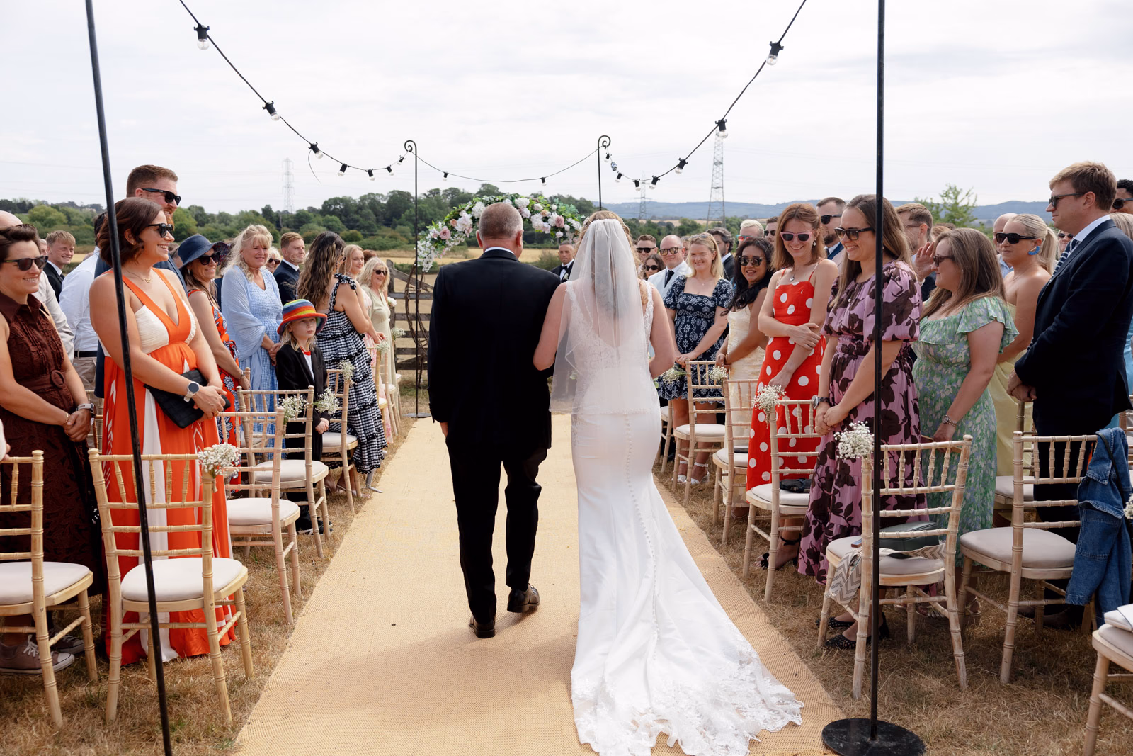 Bride walking down aisle with father at a Taunton farm wedding, photographed by Tanya Bogdan Photography