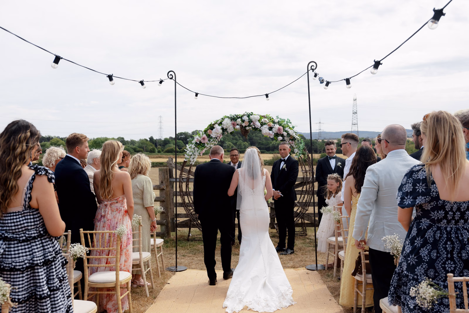 Bride and father aisle guests watching at a family farm wedding in Taunton