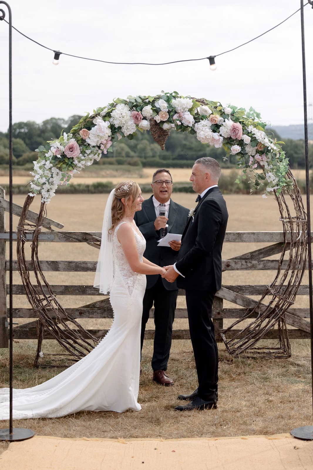 Bride and groom meeting at ceremony arch at a countryside wedding in Taunton, Somerset