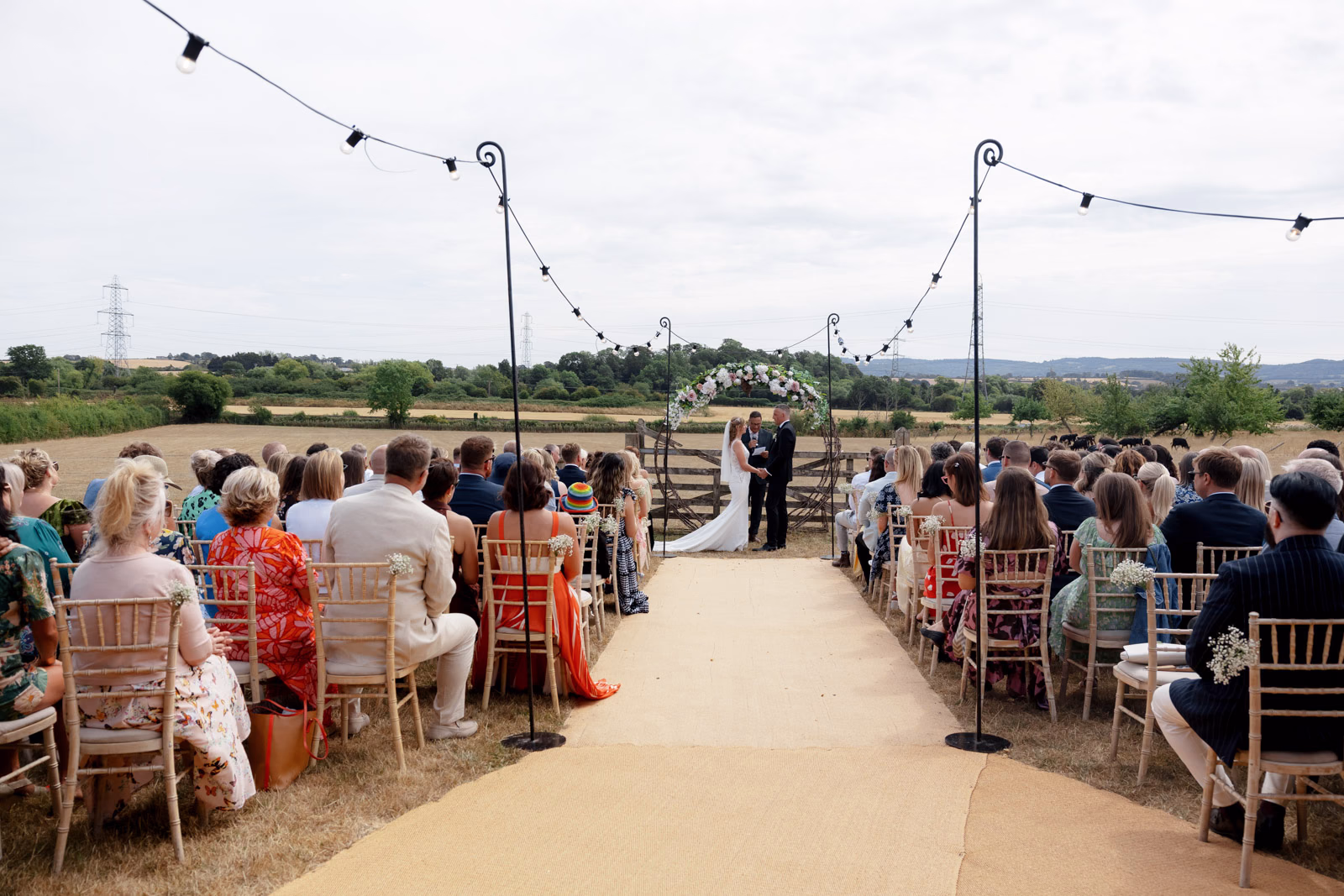 Wide view ceremony aisle guests seated at a family farm wedding in Taunton