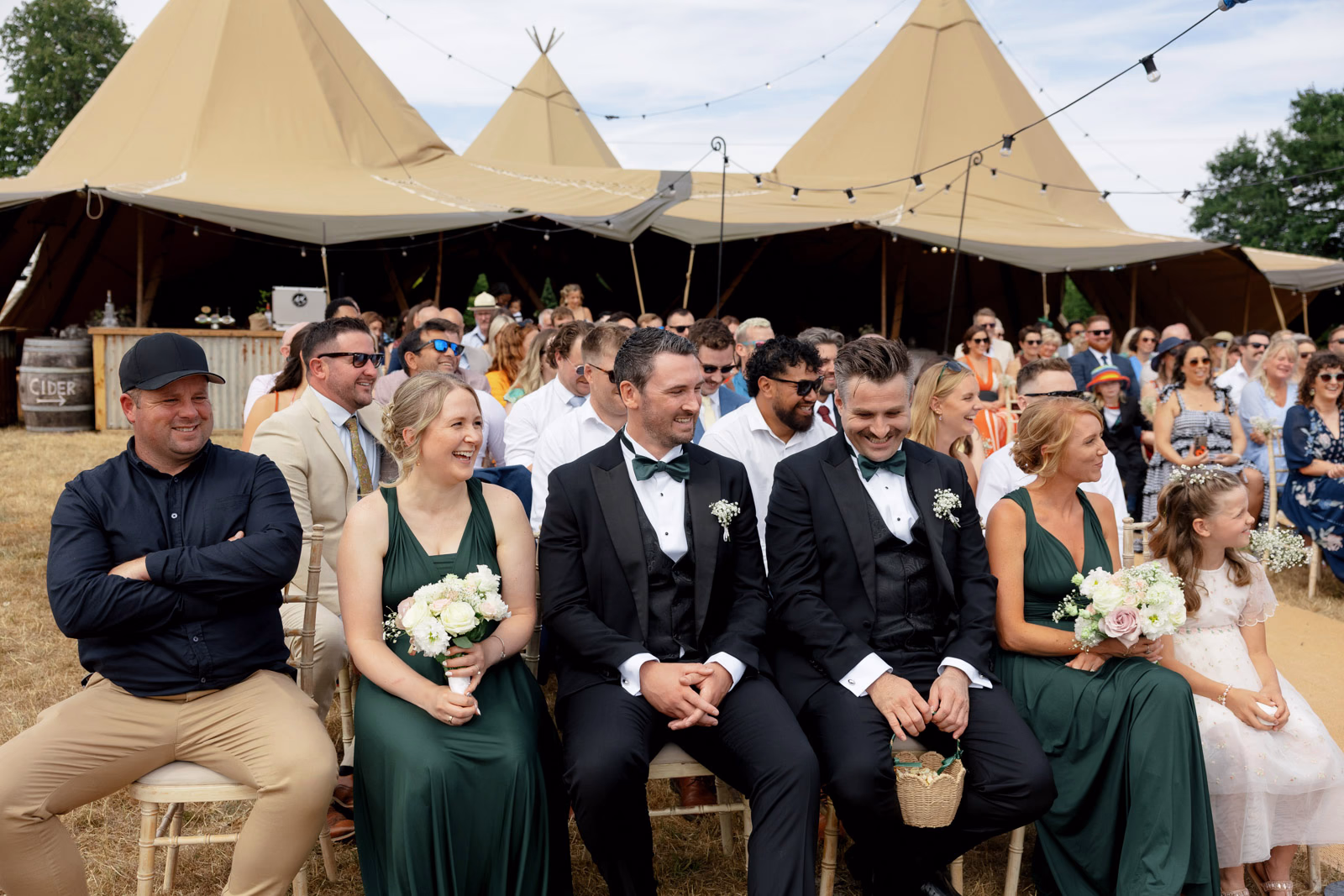 Bridesmaids and groomsmen seated ceremony at a family farm wedding in Taunton
