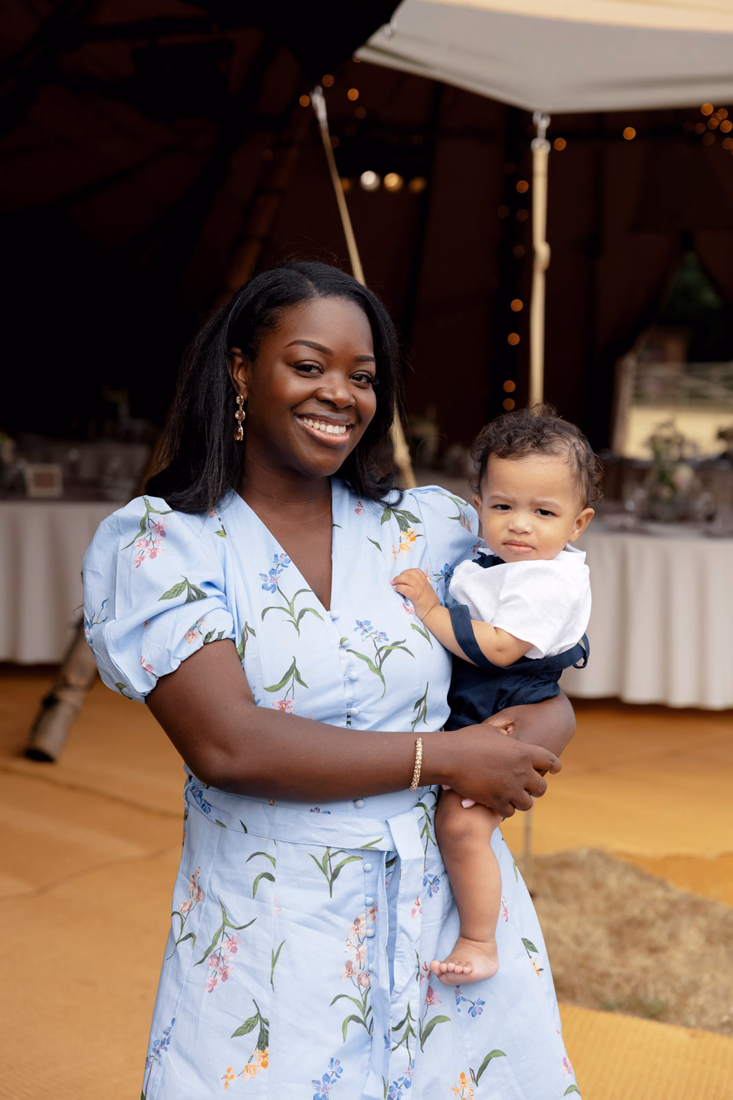 Guest holding baby at ceremony at a family farm wedding in Taunton