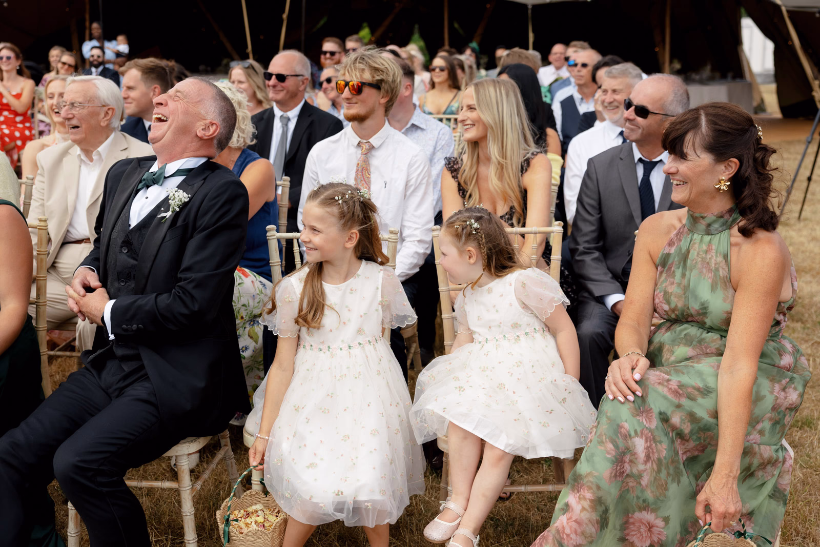 Flower girls and guests watching ceremony at a Taunton farm wedding, photographed by Tanya Bogdan Photography