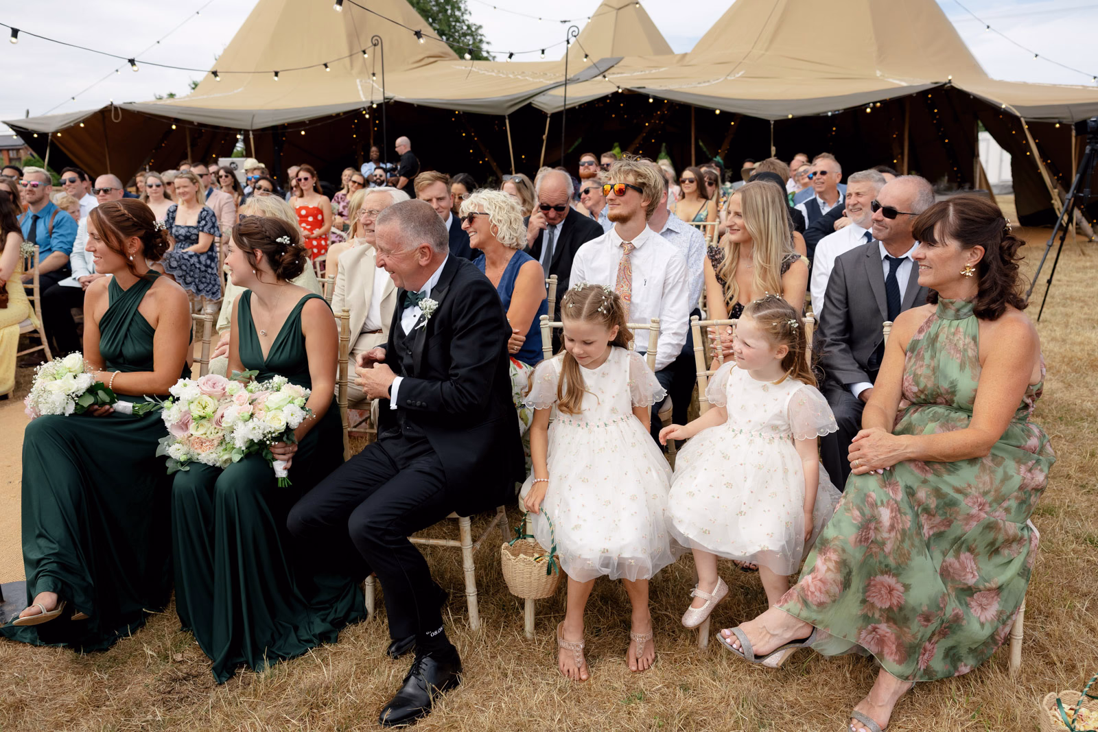 Bridesmaids and flower girls watching ceremony at a family farm wedding in Taunton
