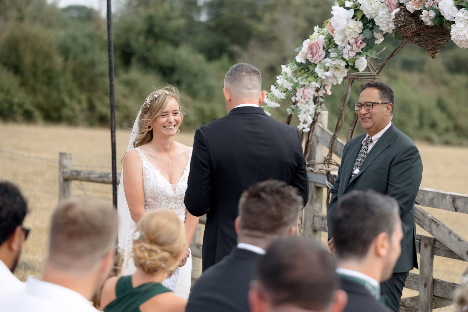 Bride and groom ceremony through guests at a family farm wedding in Taunton