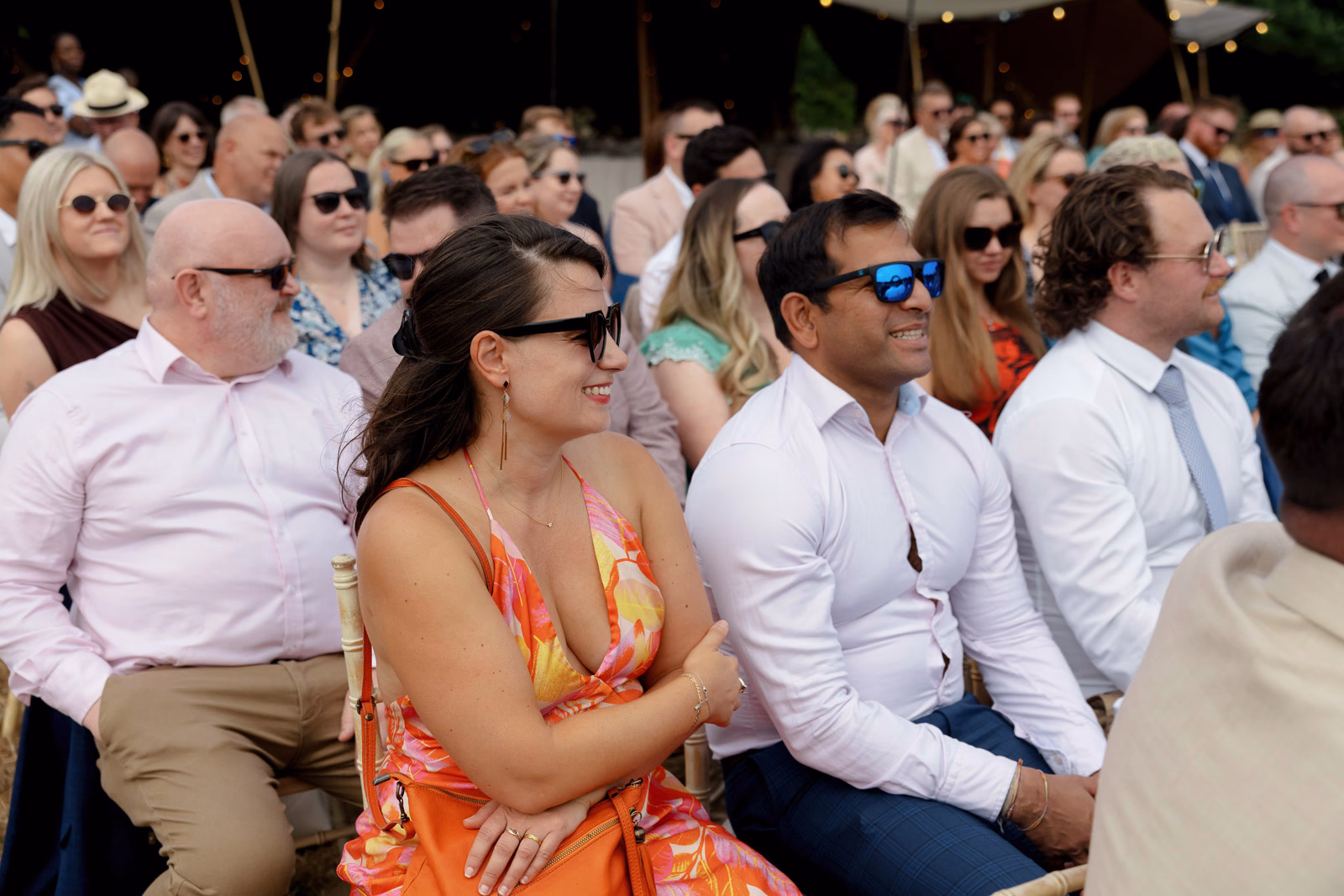 Guests watching ceremony sunglasses at a family farm wedding in Taunton