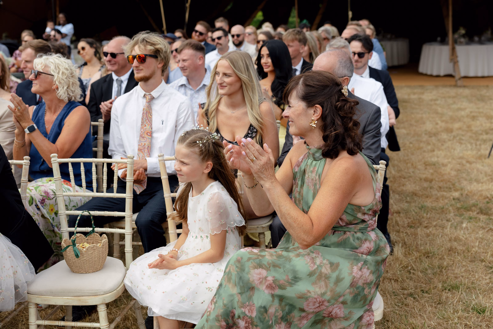 Flower girl and guest clapping ceremony at a Taunton farm wedding, photographed by Tanya Bogdan Photography