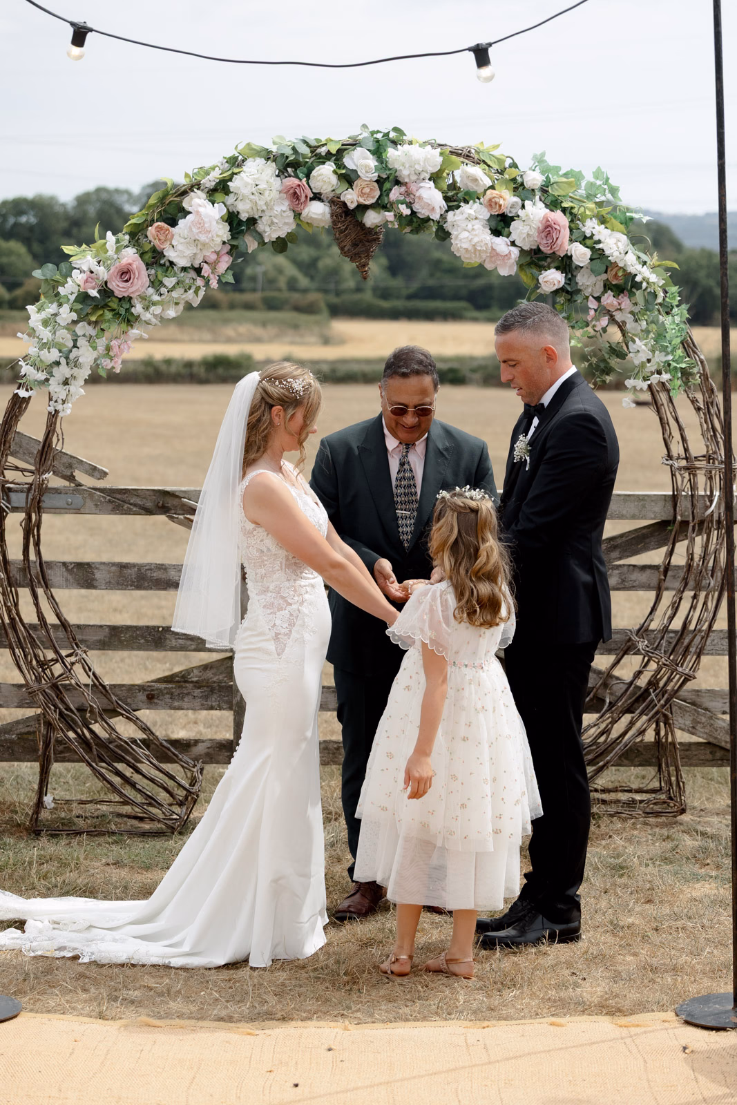 Flower girl beside bride and groom ceremony at a countryside wedding in Taunton, Somerset