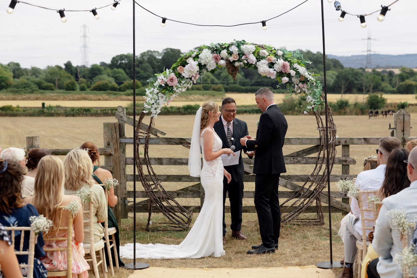 Ring exchange ceremony floral arch at a Taunton farm wedding, photographed by Tanya Bogdan Photography