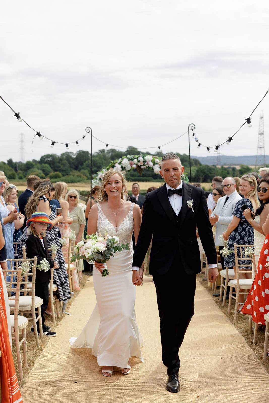 Newlyweds leaving ceremony aisle at a family farm wedding in Taunton