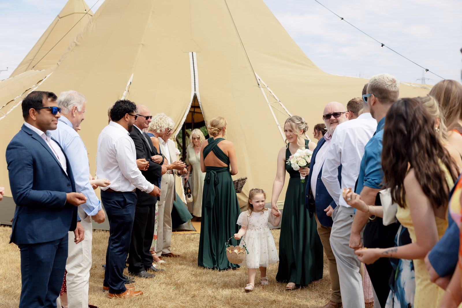 Guests gathering outside tipi after ceremony at a family farm wedding in Taunton