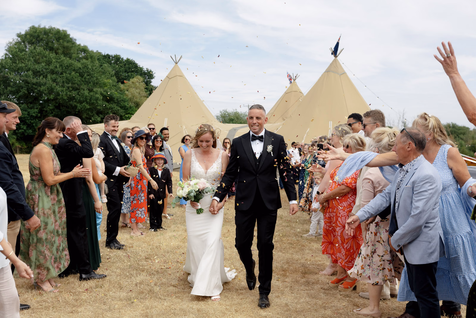 Confetti moment newlyweds walking at a family farm wedding in Taunton