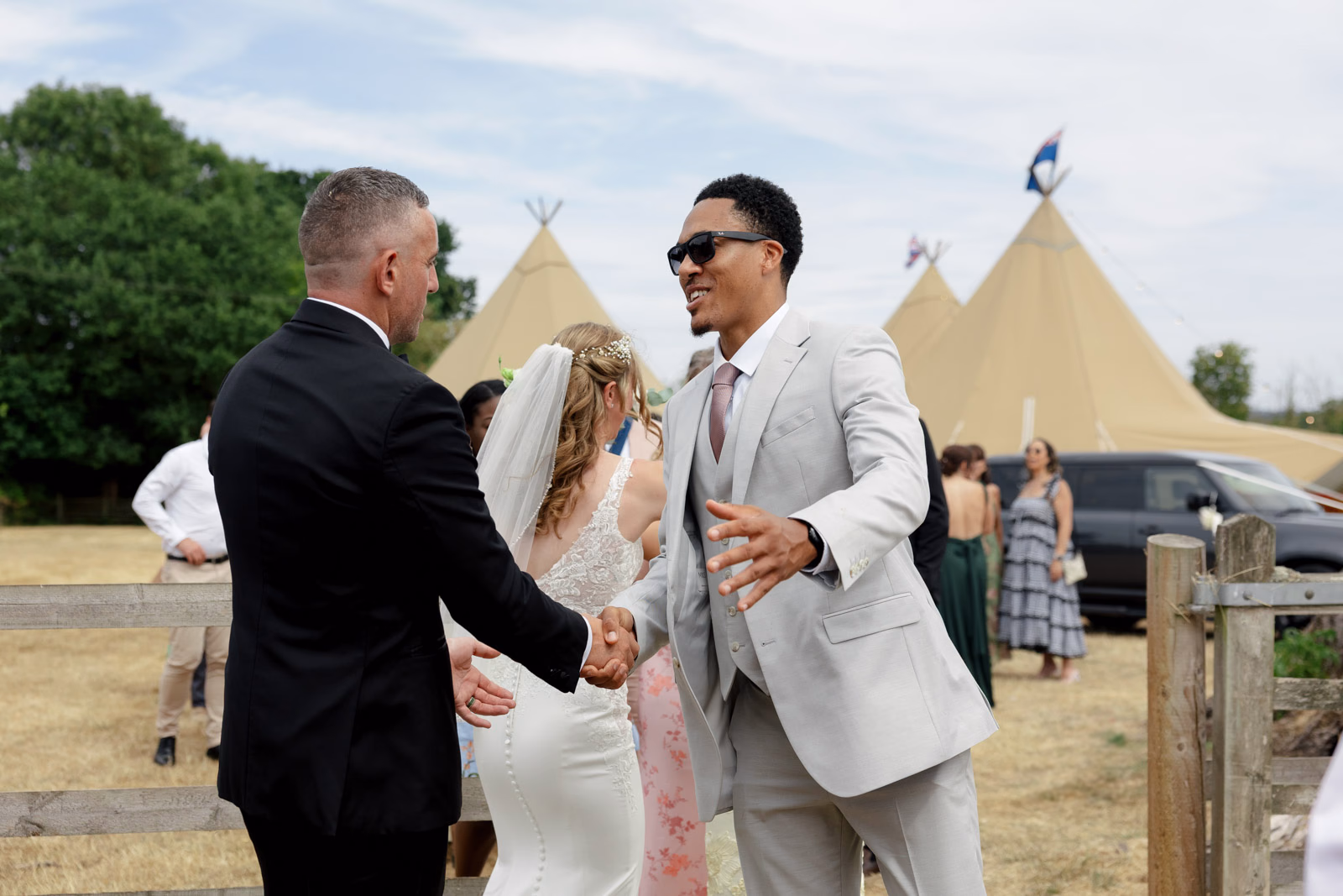Groom and guest congratulations hug at a family farm wedding in Taunton