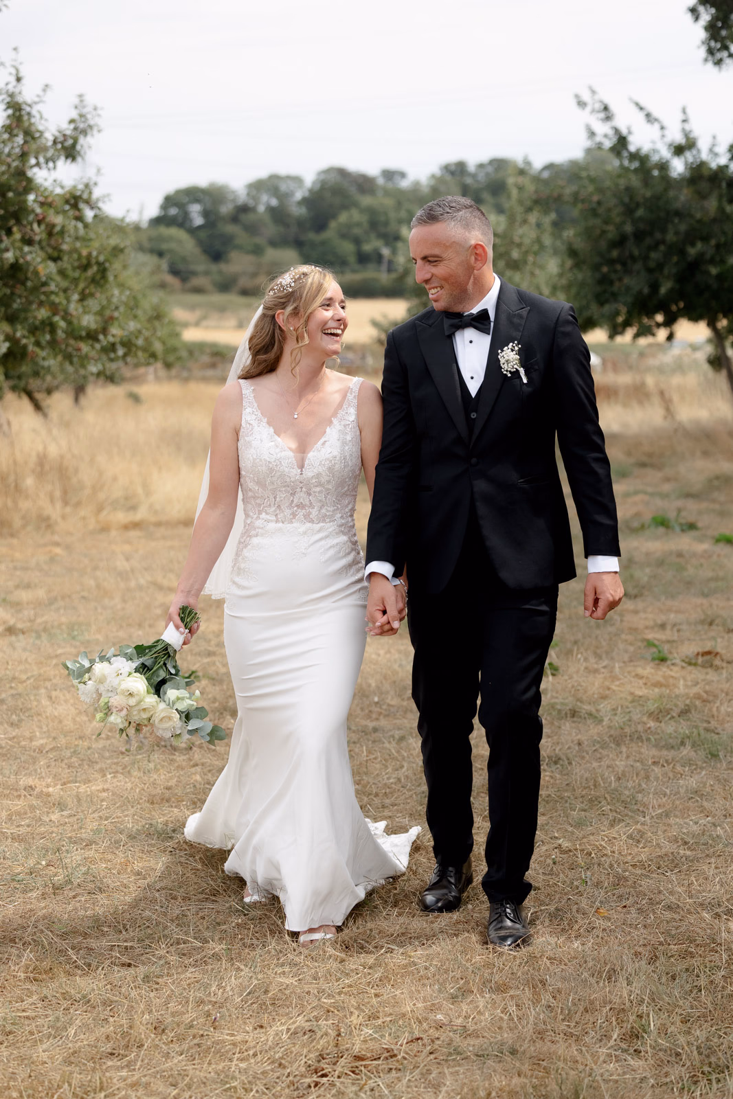 Bride and groom walking together field at a family farm wedding in Taunton