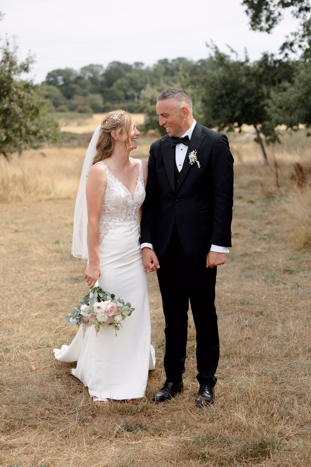 Bride and groom standing together field at a family farm wedding in Taunton