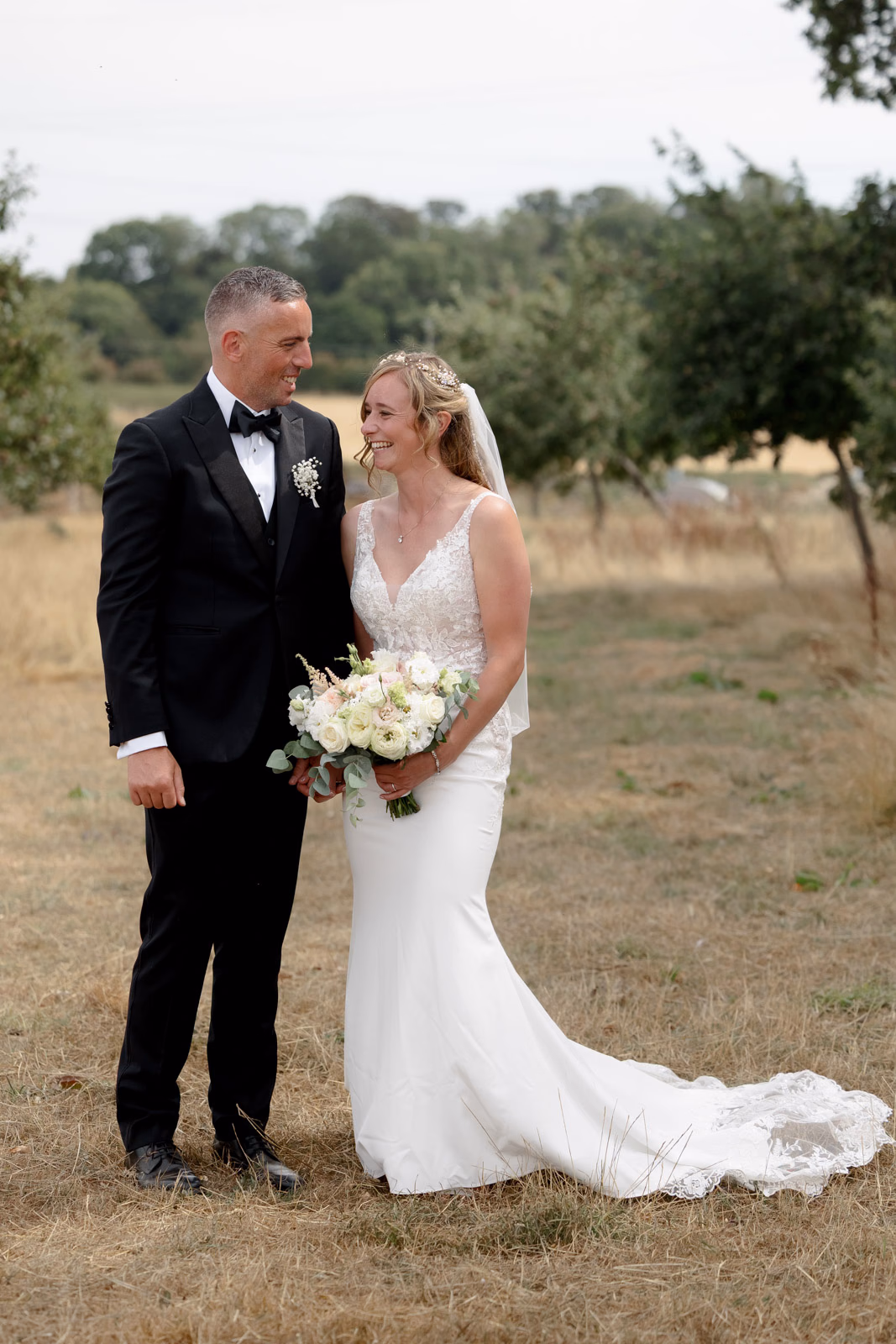 Bride and groom full-length portrait dress train at a Taunton farm wedding, photographed by Tanya Bogdan Photography