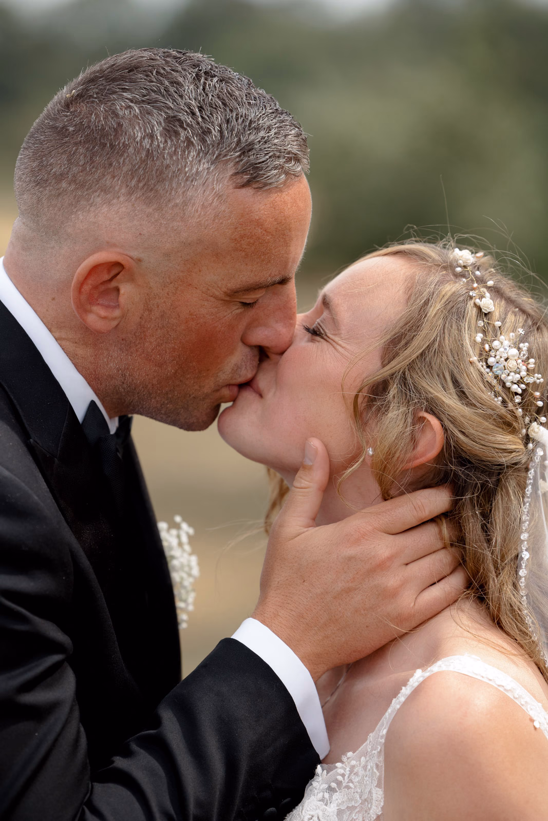 Bride and groom kiss close-up at a family farm wedding in Taunton