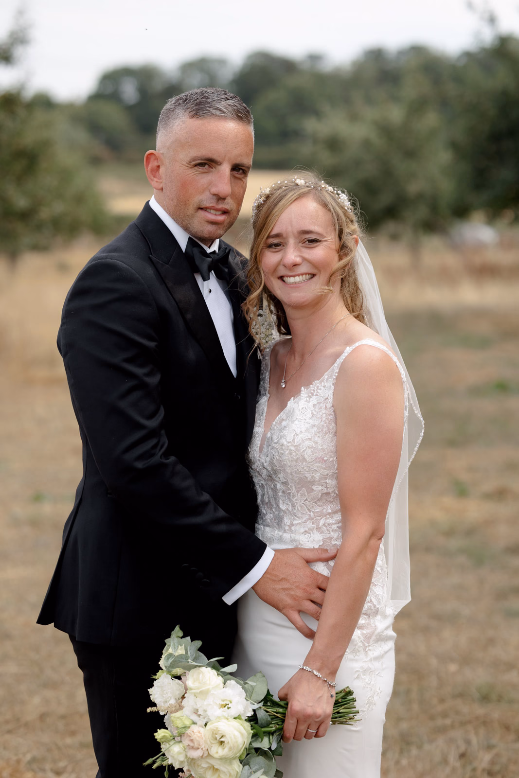 Groom hugging bride portrait at a family farm wedding in Taunton