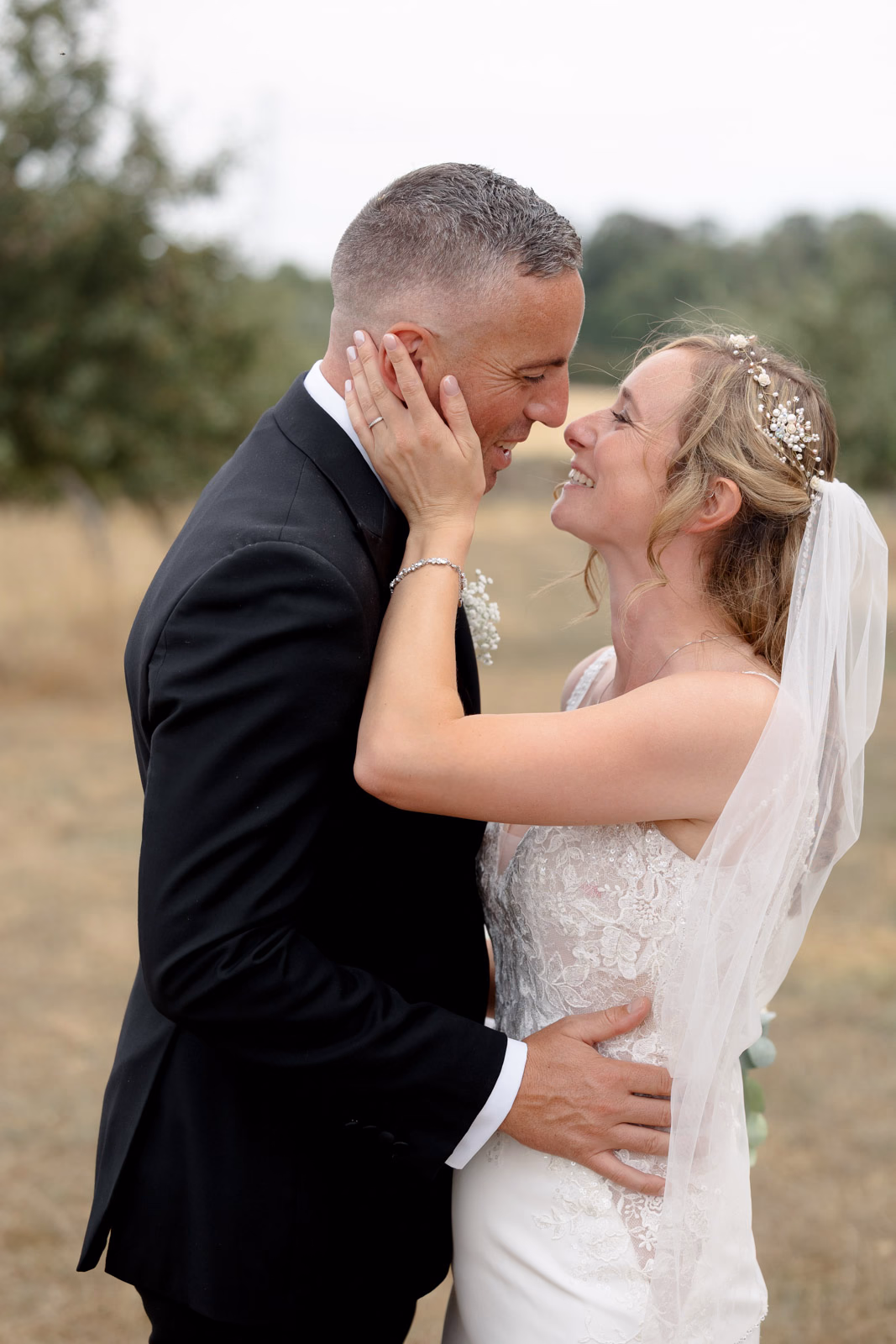 Bride and groom kiss embrace orchard at a Taunton farm wedding, photographed by Tanya Bogdan Photography