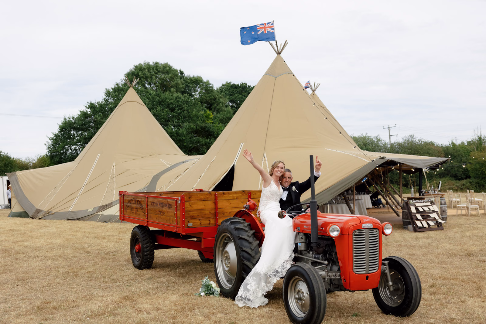 Bride on vintage red tractor at a family farm wedding in Taunton