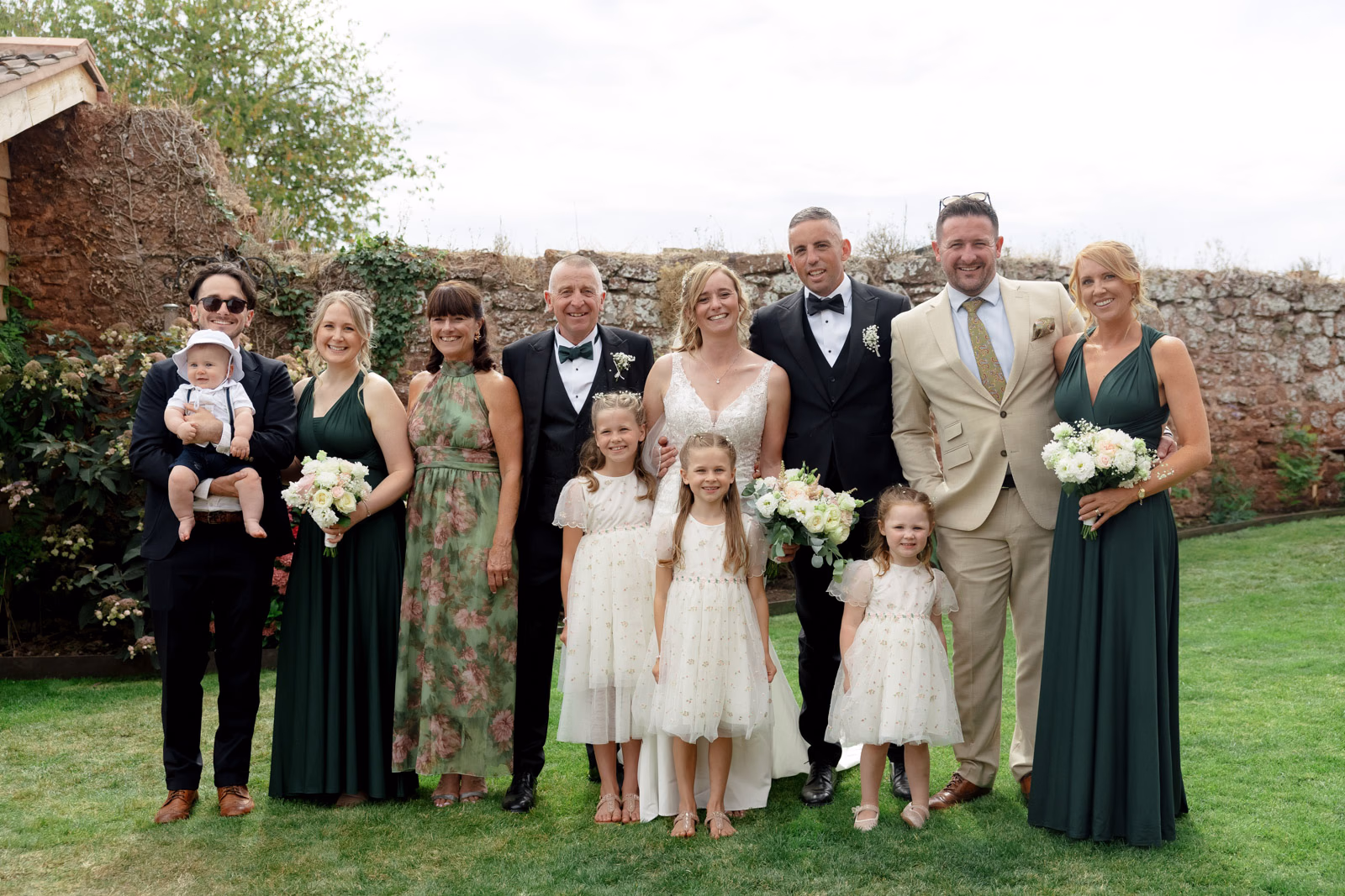 Family group photo with flower girls at a family farm wedding in Taunton