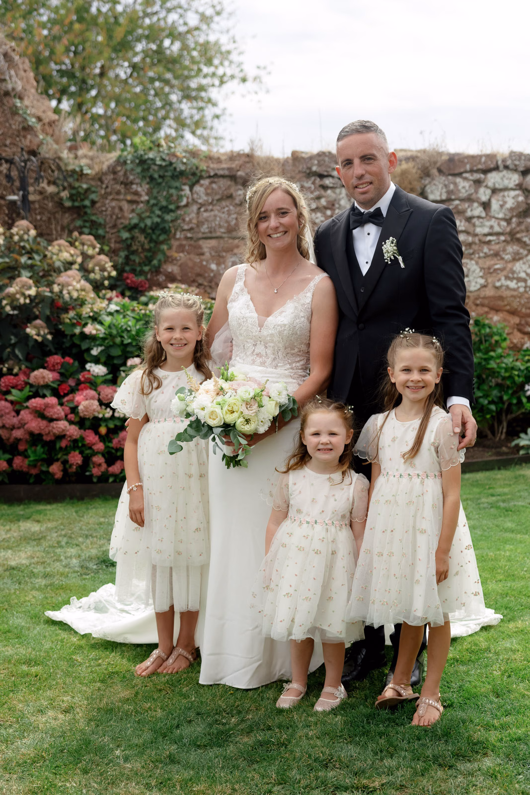 Bride with flower girls portrait garden at a family farm wedding in Taunton