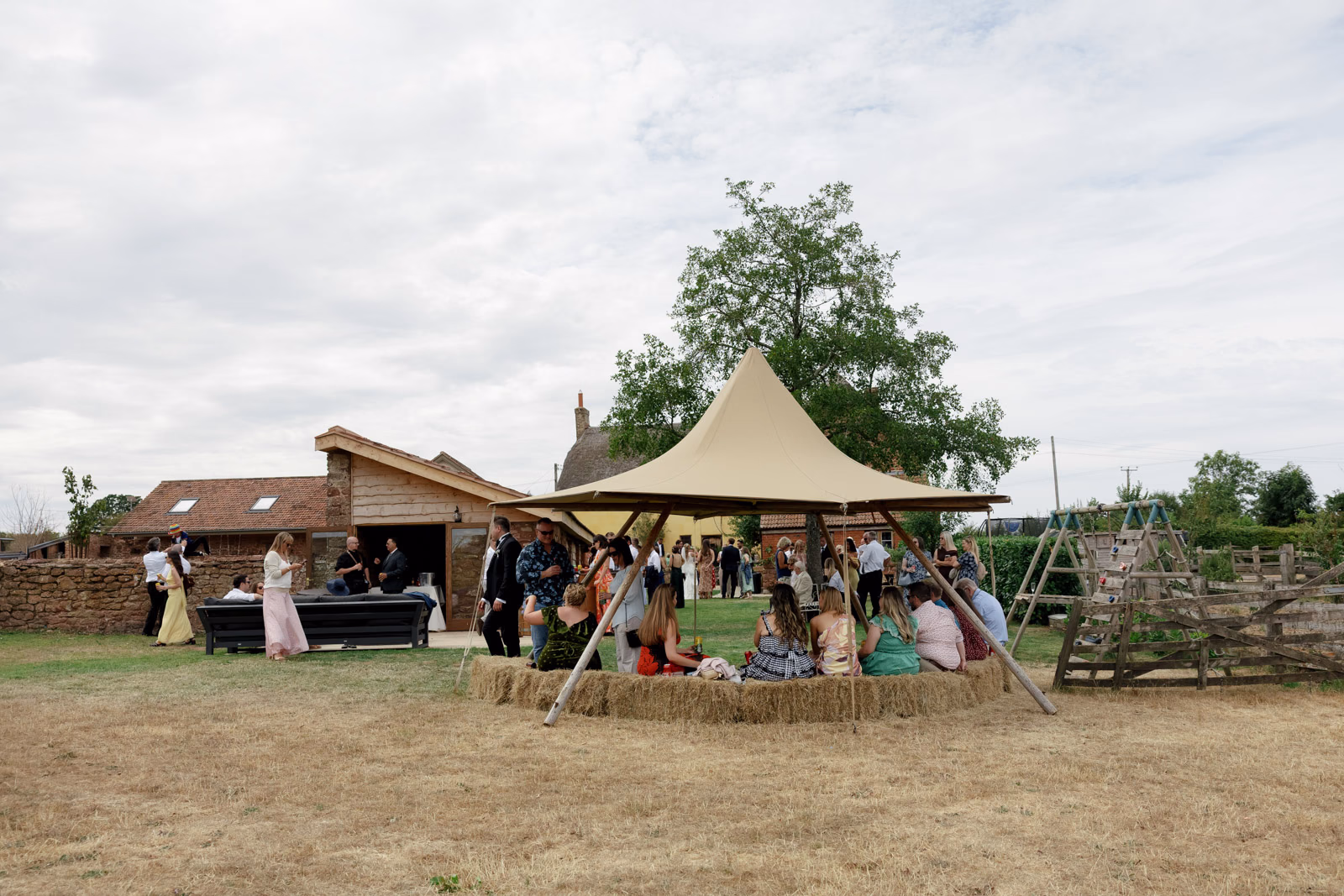 Guests relaxing by tipi bar at a countryside wedding in Taunton, Somerset