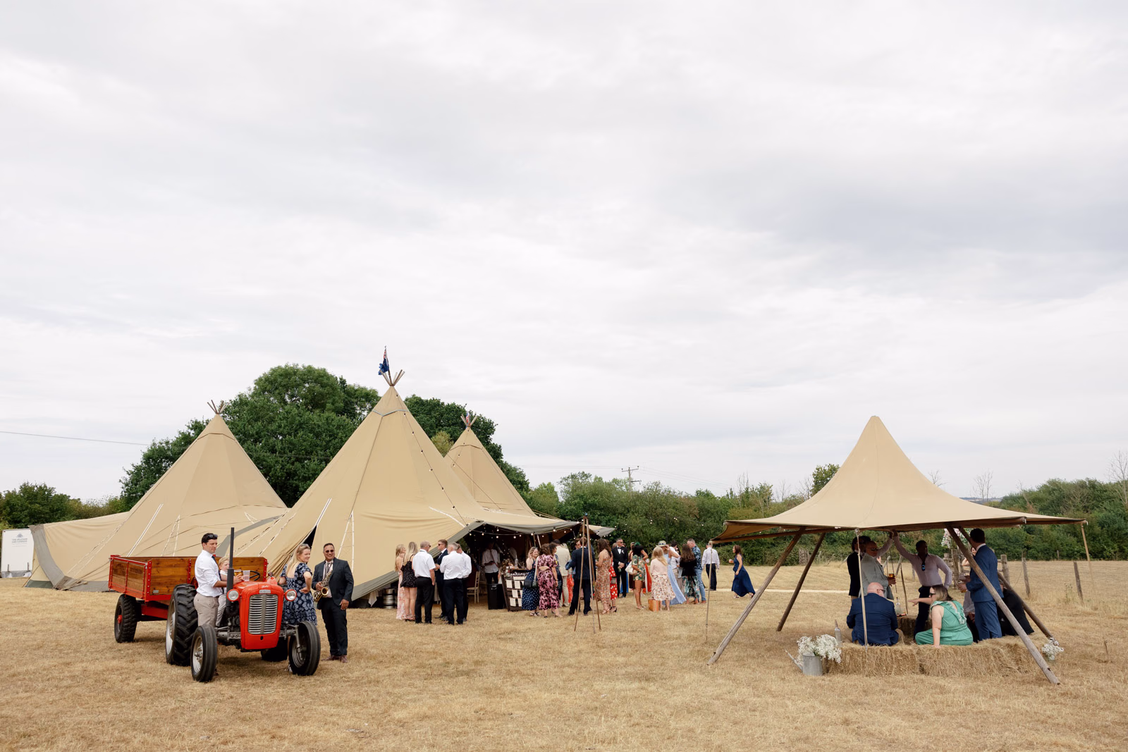 Guests queuing tipi bar tractor at a Taunton farm wedding, photographed by Tanya Bogdan Photography