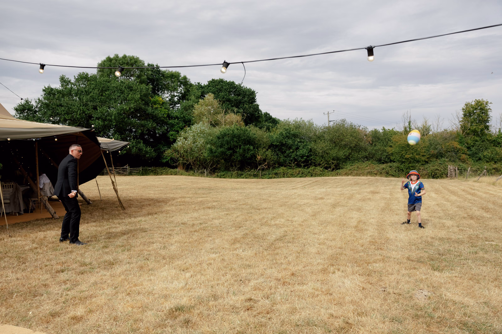 Child playing in field farm at a countryside wedding in Taunton, Somerset