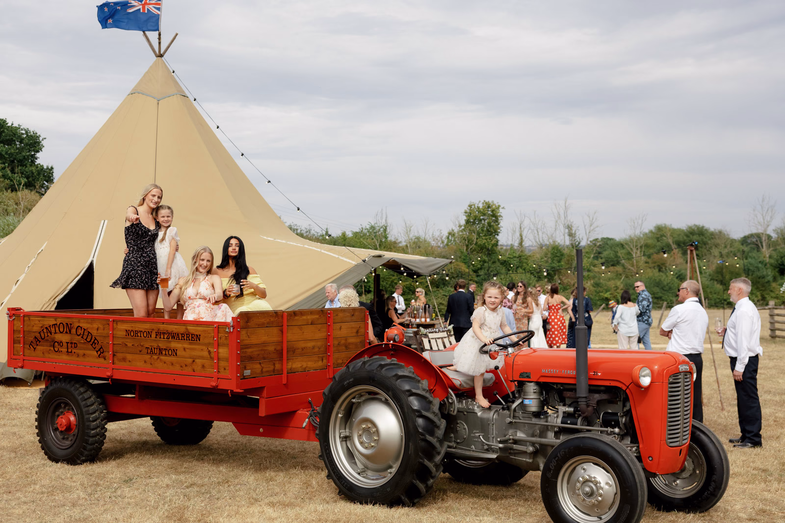 Guests on tractor trailer tipi at a family farm wedding in Taunton