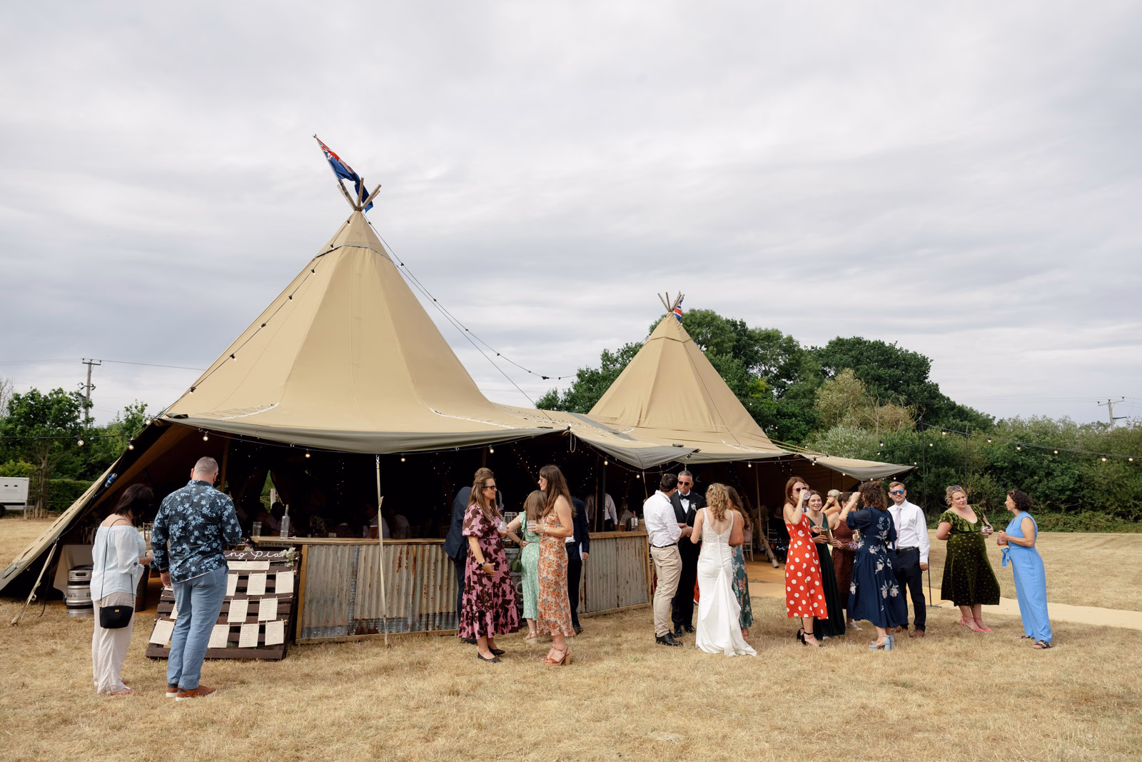Guests mingling tipi drinks reception at a countryside wedding in Taunton, Somerset