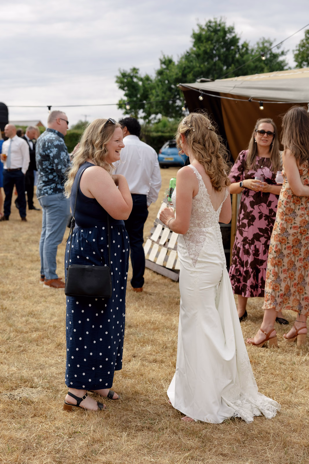 Bride chatting with guests drinks reception at a Taunton farm wedding, photographed by Tanya Bogdan Photography