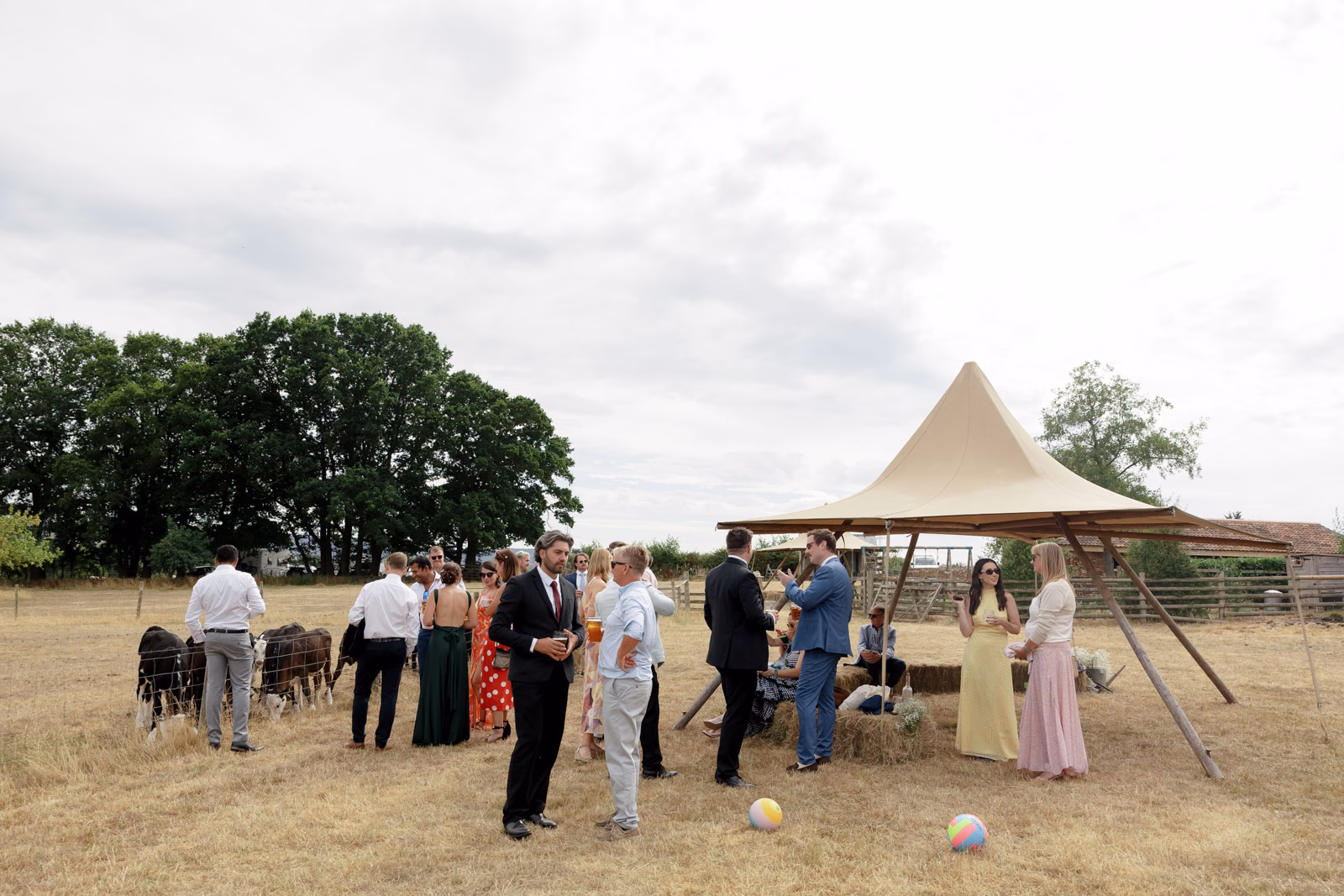 Guests playing lawn games tipi at a family farm wedding in Taunton