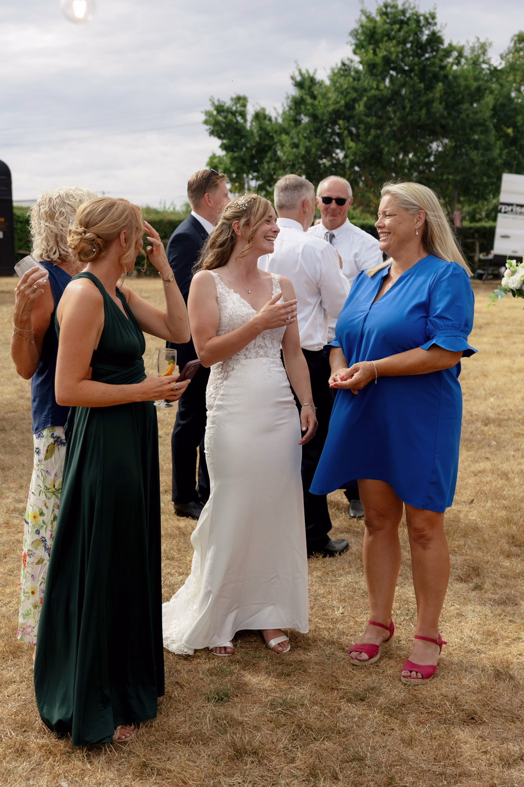 Bride chatting with bridesmaid drinks reception at a family farm wedding in Taunton
