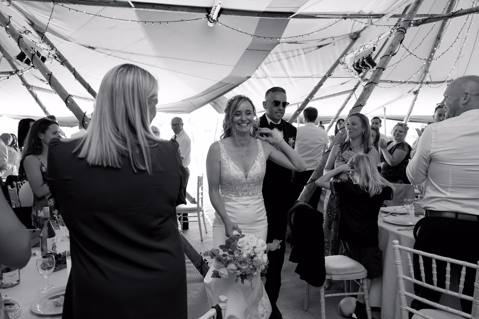 Bride entering tipi black-and-white at a countryside wedding in Taunton, Somerset