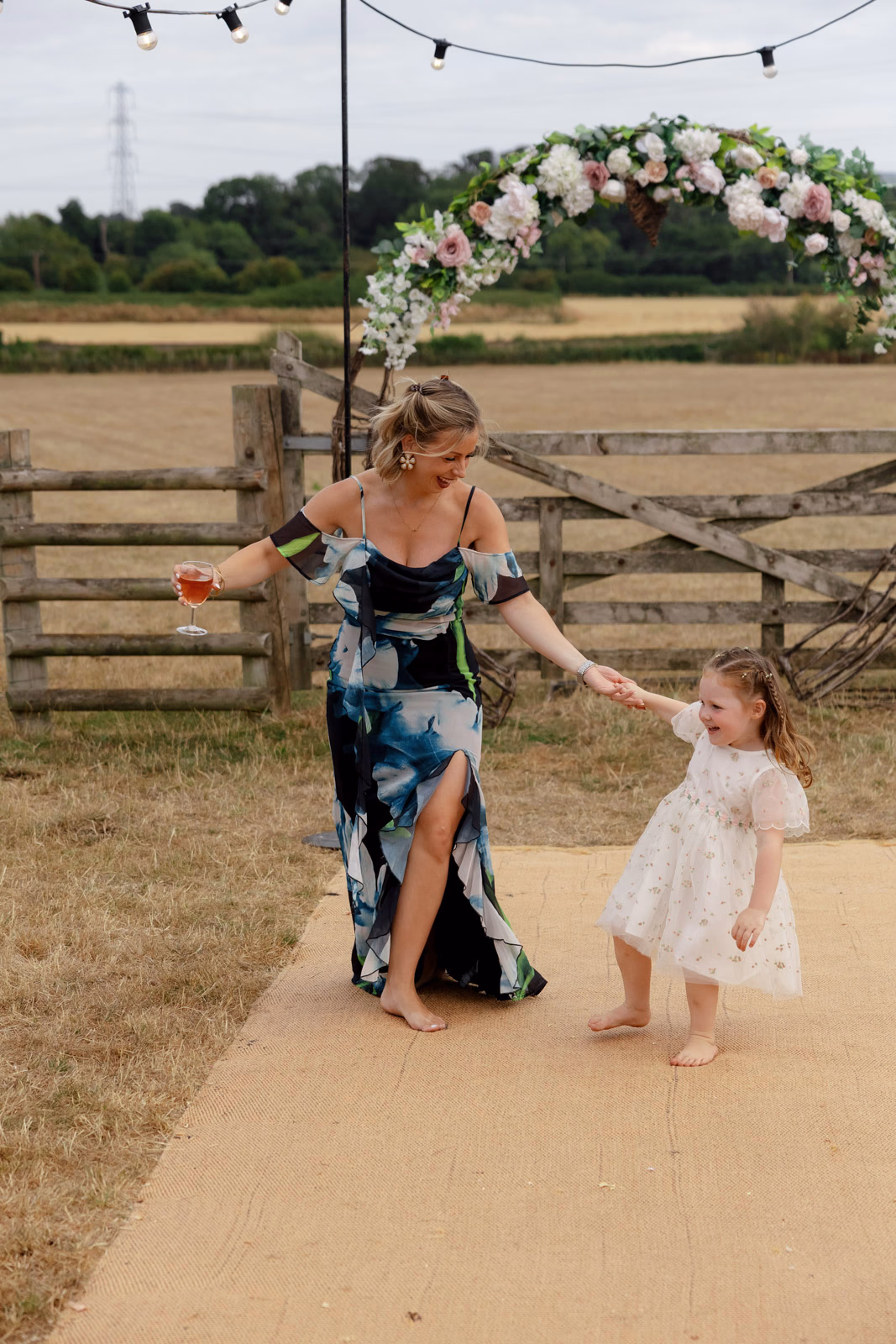 Guest dancing with flower girl at a Taunton farm wedding, photographed by Tanya Bogdan Photography