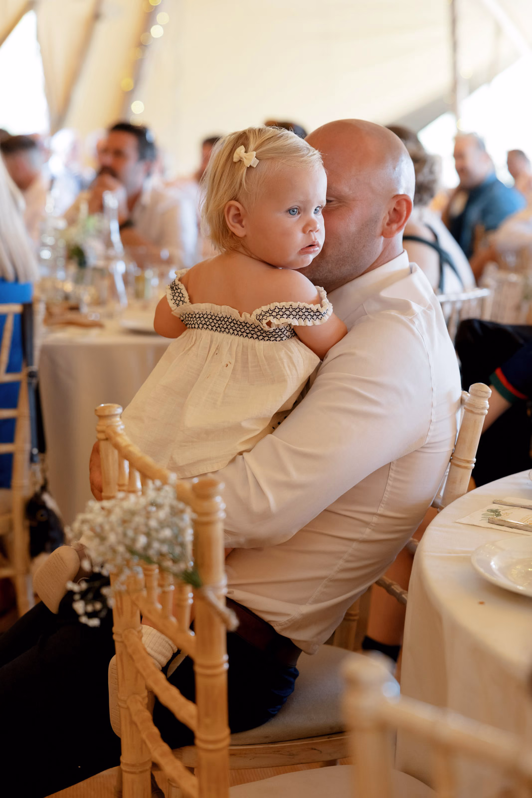 Toddler with dad at reception table at a family farm wedding in Taunton